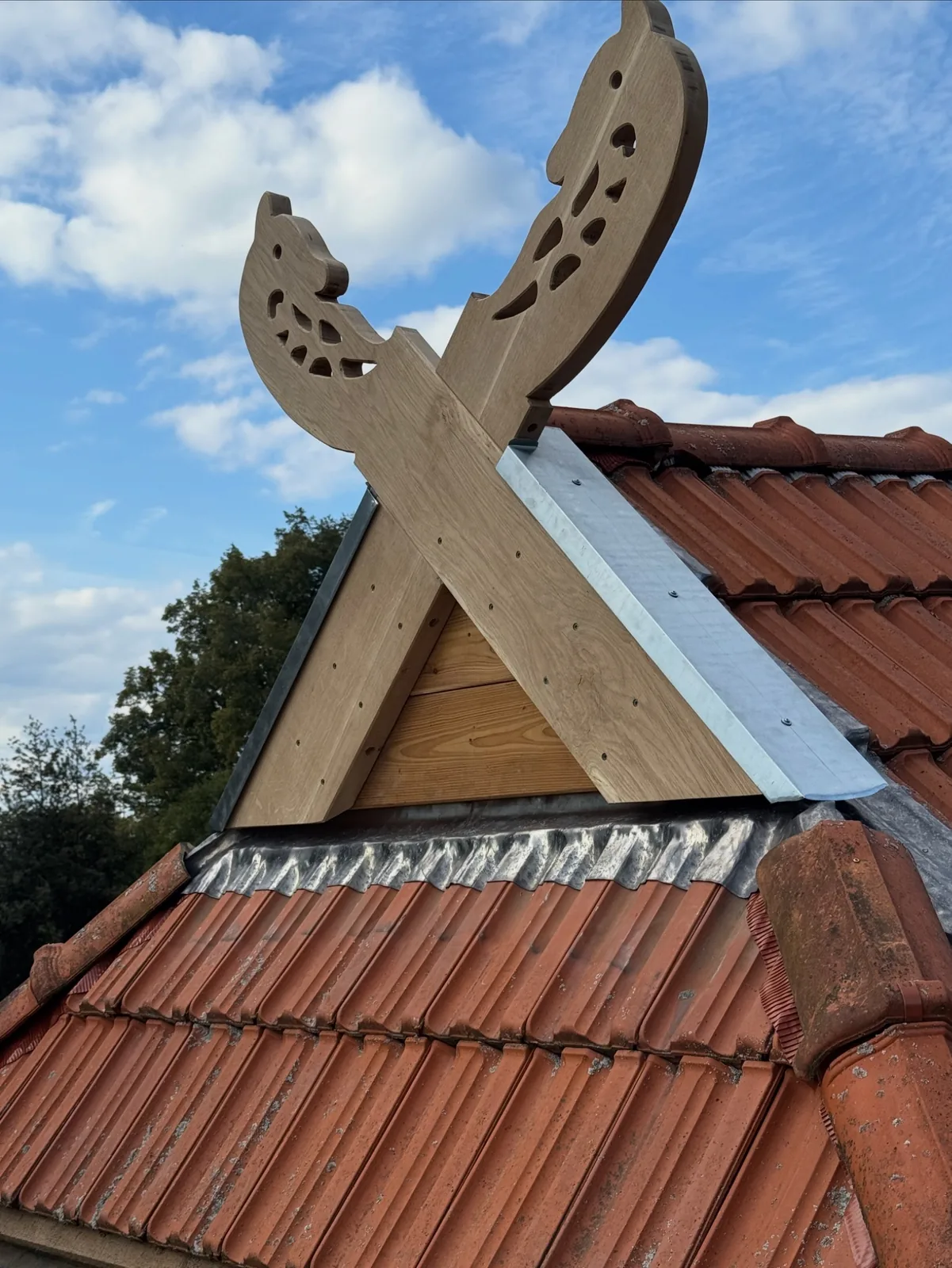 Handgefertigte Pferdeköpfe an einem Bestandsdach